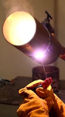 Bir adam metal bir boruyu kaynak yapar.