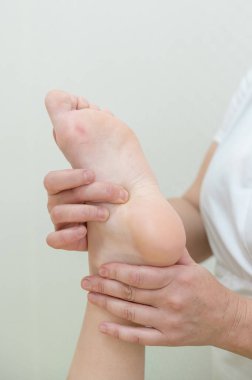 Bir kadının ayağına masaj yapılıyor.