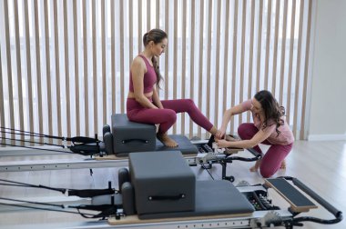 Kişisel pilates eğitimi. Eğitmen, kadını reformcuya alıştırdı