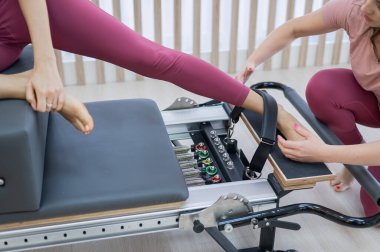 Kişisel pilates eğitimi. Eğitmen, kadını reformcuya alıştırdı