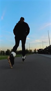 Akşamları paten kayan beyaz kadın. Slalom. Dikey video