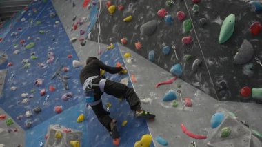 Beyaz adam tırmanma duvarında eğitim görüyor.