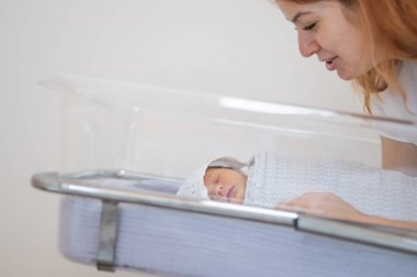 Genç bir anne, doğumevindeki yeni doğan oğluna hayran.