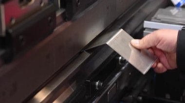 Bir usta, bir makinenin metal levhalarını büker. Hidrolik Basınç