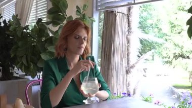 Caddedeki kafede samandan kokteyl içen mutlu beyaz kadın. Yavaş çekim