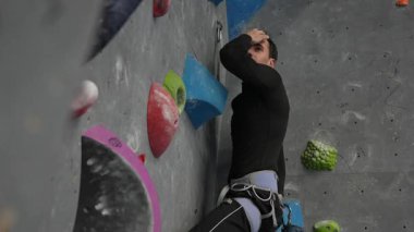 Beyaz adam tırmanma duvarında eğitim görüyor.