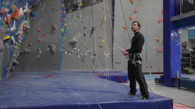 Beyaz adam tırmanma duvarında eğitim görüyor.