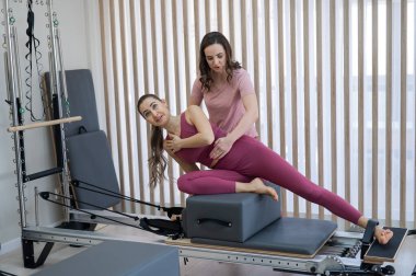 Kişisel pilates eğitimi. Eğitmen, kadını reformcuya alıştırdı