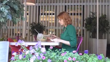 Sokak kafesinde çorba içen mutlu beyaz kadın. Yavaş çekim