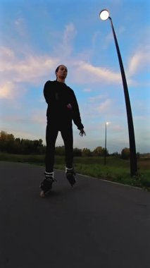 Akşamları paten kayan beyaz kadın. Slalom. Dikey video