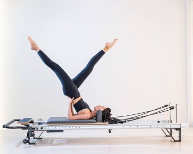 Asyalı kadın reformcuda pilates yapıyor.