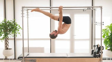 Bir adam yenilikçi bir makine üzerinde hava tatbikatları yapıyor.