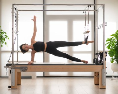 Asyalı kadın reformcuda pilates yapıyor.