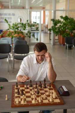 Beyaz adam satranç hamlesi düşünüyor.