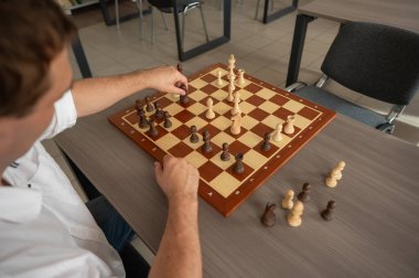 Beyaz adam satranç hamlesi düşünüyor.