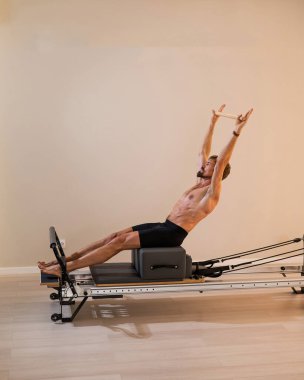 Reformcu üzerinde pilates yapan bir adam.