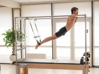 Bir adam yenilikçi bir makine üzerinde hava tatbikatları yapıyor.