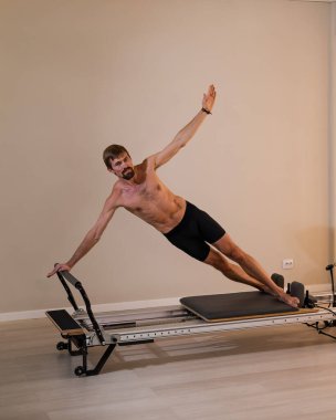 Reformcu üzerinde pilates yapan bir adam.