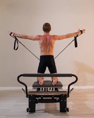 Reformcu üzerinde pilates yapan bir adam.