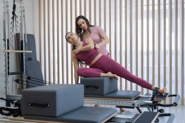 Kişisel pilates eğitimi. Eğitmen, kadını reformcuya alıştırdı