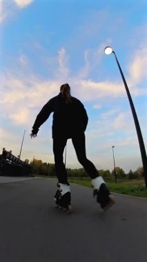 Akşamları paten kayan beyaz kadın. Slalom. Dikey video