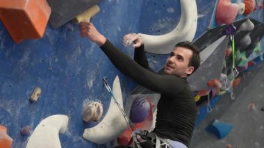 Beyaz adam tırmanma duvarında eğitim görüyor.