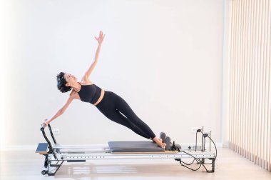 Asyalı kadın reformcuda pilates yapıyor.