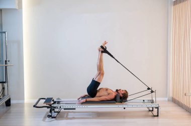 Reformcu üzerinde pilates yapan bir adam.