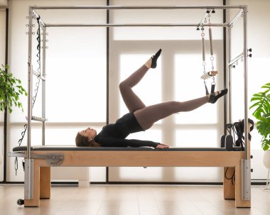 Reform üzerine pilates yapan kadın