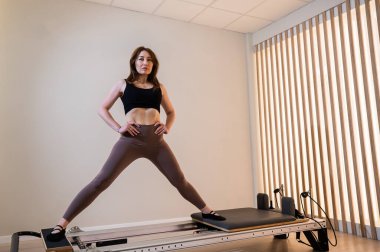 Asyalı kadın reformcuda pilates yapıyor.