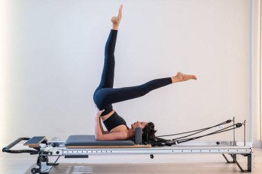 Asyalı kadın reformcuda pilates yapıyor.