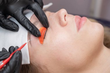 Beyaz kadın kirpik temizleme prosedüründen geçiyor.