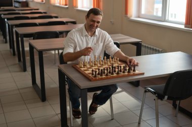 Beyaz adam satranç hamlesi düşünüyor.