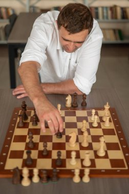 Beyaz adam satranç hamlesi düşünüyor.