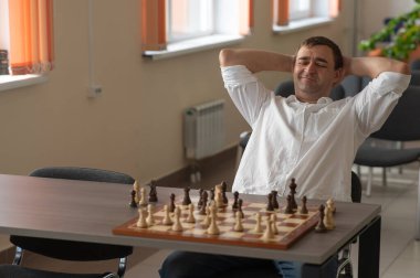 Beyaz adam satranç hamlesi düşünüyor.