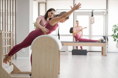 Bir antrenör, kadını merdiven fıçısında ayarlar. 