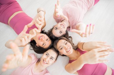 İki Kafkasyalı ve iki Asyalı kadın spor giyim kuşamında uzanır.