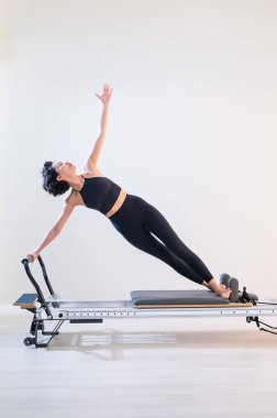 Asyalı kadın reformcuda pilates yapıyor.