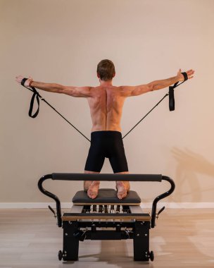 Reformcu üzerinde pilates yapan bir adam.