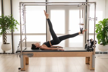 Asyalı kadın reformcuda pilates yapıyor.