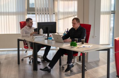 Bir ofiste çalışan iki beyaz adam.