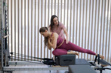 Kişisel pilates eğitimi. Eğitmen, kadını reformcuya alıştırdı