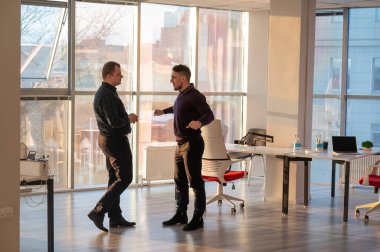 Ofiste konuşan iki beyaz adam.