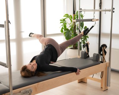 Reform üzerine pilates yapan kadın