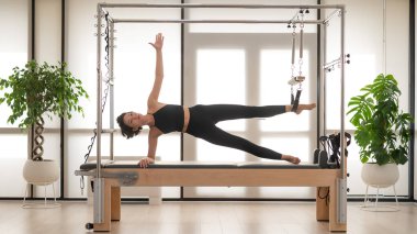 Asyalı kadın reformcuda pilates yapıyor.