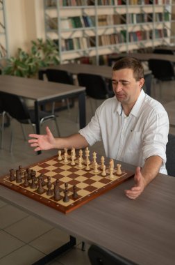 Beyaz adam satranç hamlesi düşünüyor.