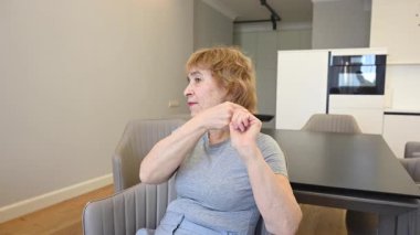 Saçlarını tarayan yaşlı beyaz bir kadın.