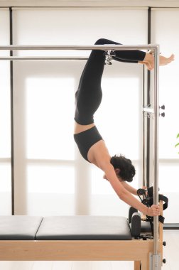 Yenilikçi makine üzerinde hava egzersizi yapan Asyalı kadın.