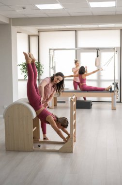 Bir antrenör, kadını merdiven fıçısında ayarlar. 