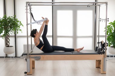 Asyalı kadın reformcuda pilates yapıyor.